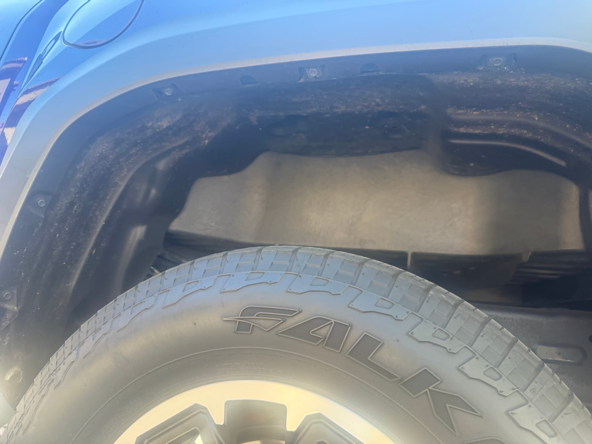 Cleaned wheel well and tire on a blue Toyota Tacoma